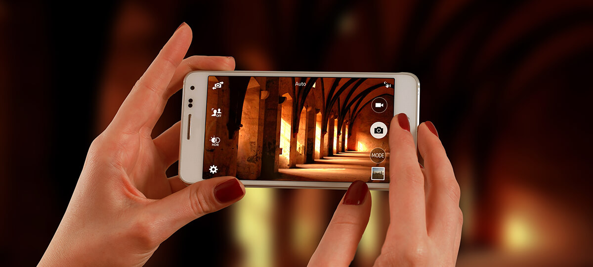 Woman hands holding smartphone taking picture of interior building of arches